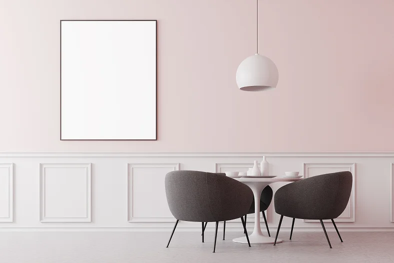Minimale eethoek met moderne stoelen, zachte pastelkleurige muren en elegante lambrisering, ontworpen voor een rustig en stijlvol interieur.