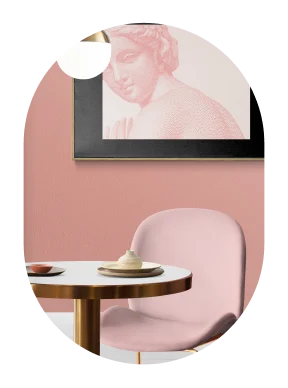 Modern interieur met pastelroze stoelen, ronde tafel, hanglamp en ingelijste wanddecoratie die een stijlvolle en gezellige sfeer creëren.